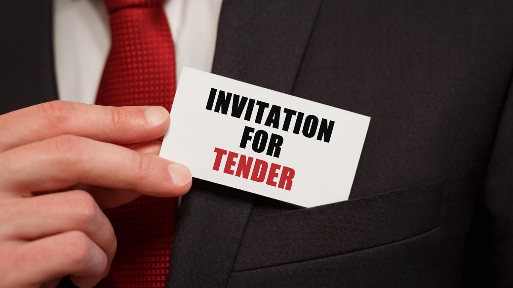 Businessman putting a card with text INVITATION FOR TENDER in the pocket