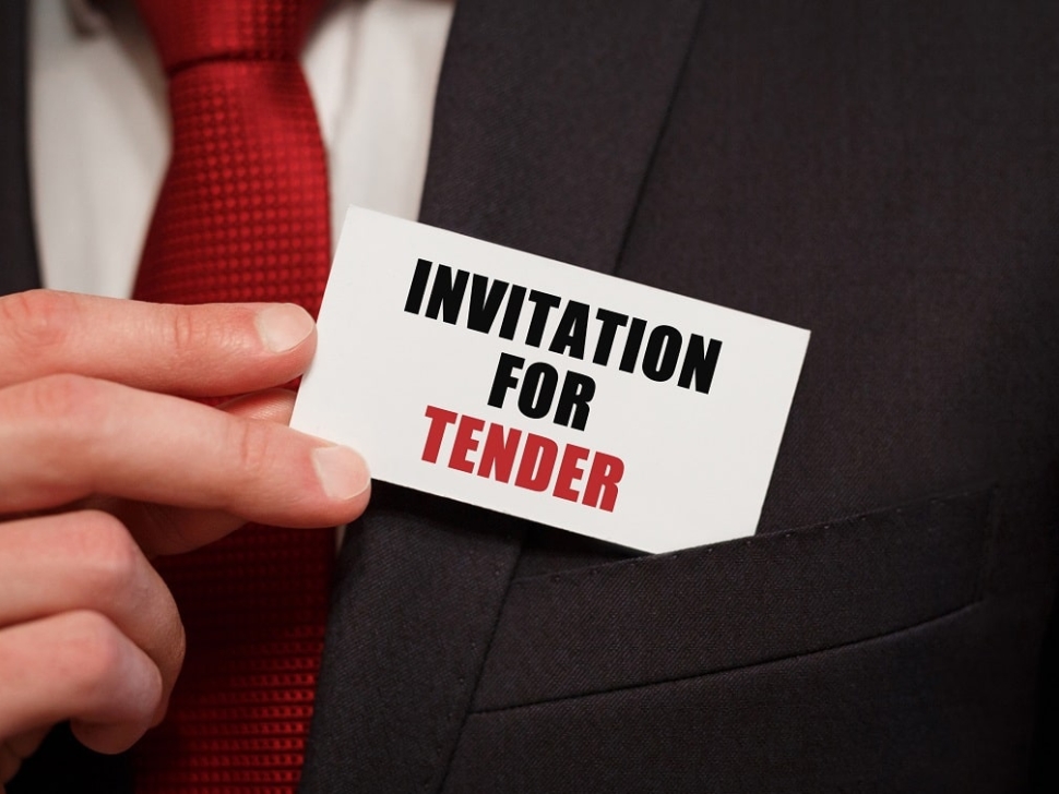 Businessman putting a card with text INVITATION FOR TENDER in the pocket