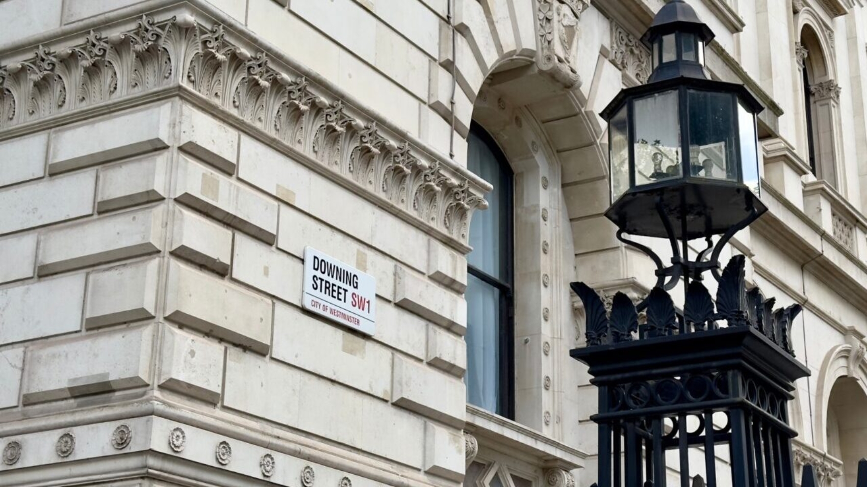 Downing Street sign on the wall of a government building in Westminster, London, England.
